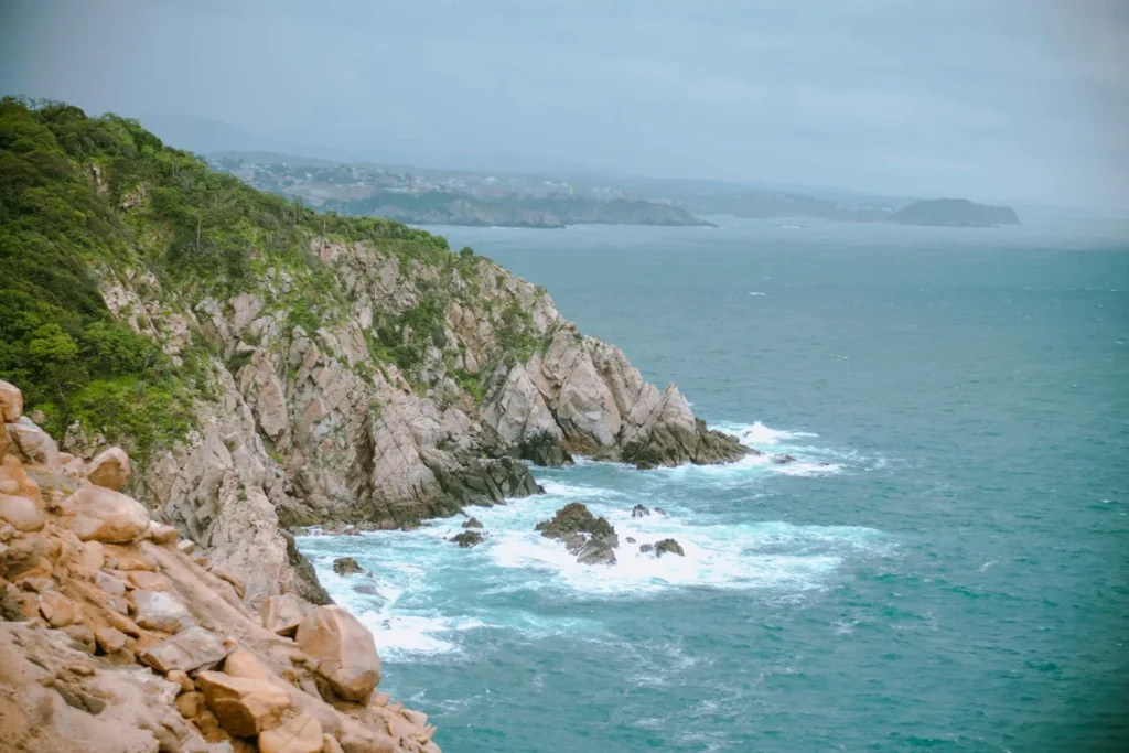 30+ Best Things to Do in Huatulco Oaxaca (2026 Guide) Dramatic rocky cliffs and crashing waves along Huatulco's rugged Pacific coastline